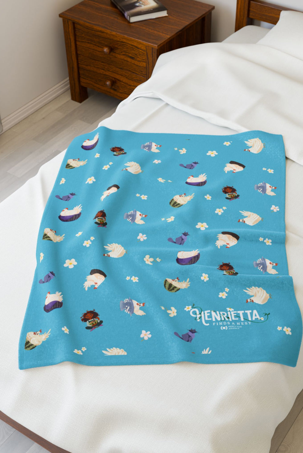 Patterned velveteen blanket with chicken, cat, and little girl cartoon characters and flowers on a blue background