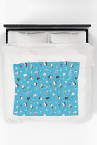 Patterned childrens velveteen blanket with chicken, cat, and little girl cartoon characters and flowers on a blue background